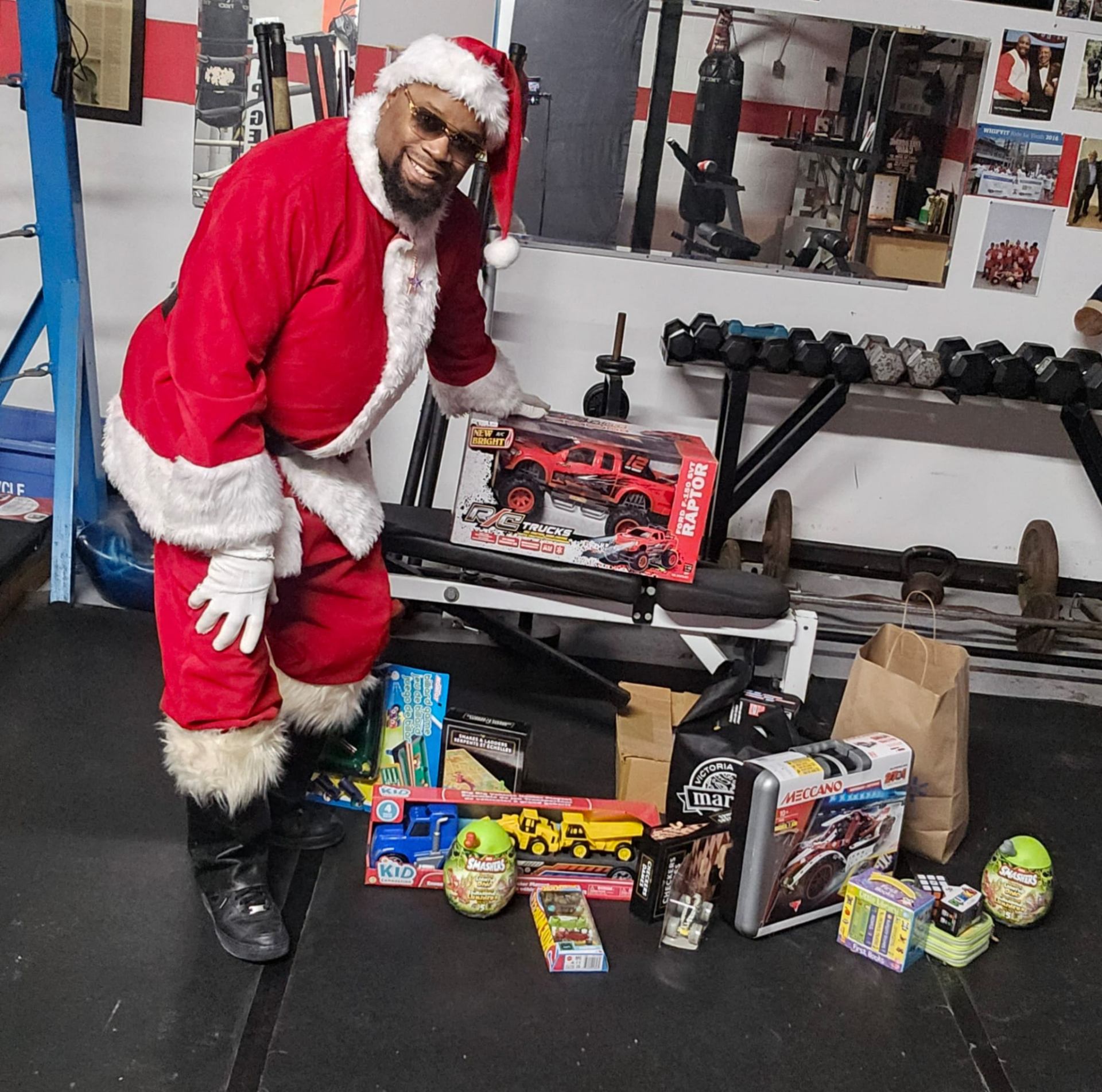 Fitz as Santa at The Whip gym with a haul of donated toys — R/C trucks, board games and building sets — ready for the community toy drive
