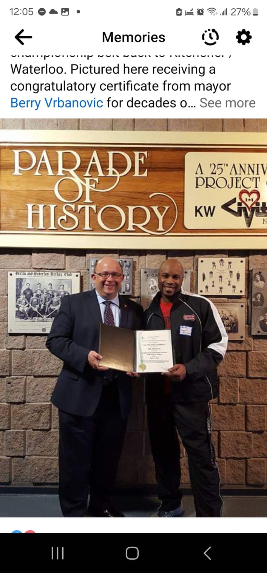 Fitz Vanderpool receiving a congratulatory certificate from Kitchener Mayor Berry Vrbanovic at the Parade of History wall
