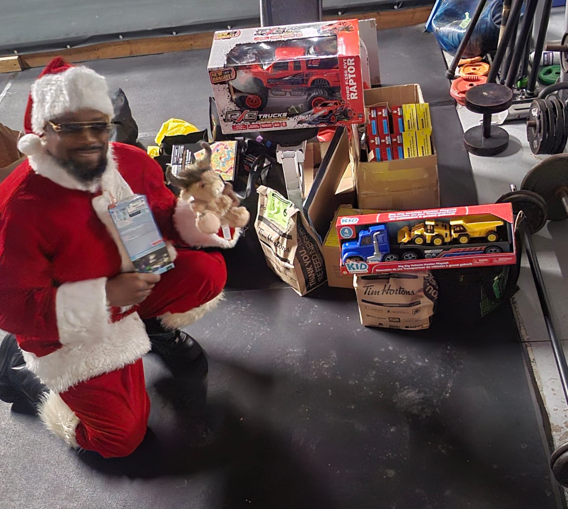 Fitz as Santa with a pile of donated toys collected at The Whip Boxing Academy for the annual community toy drive